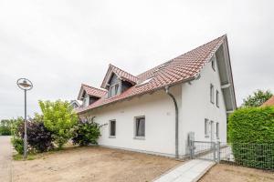 a white house with a red roof at Domizil Eden - Obergeschoss in Göhren-Lebbin