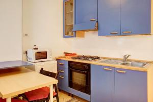 a kitchen with blue cabinets and a sink and a table at Foresteria al Cantun in Sondrio