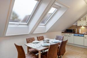 a dining room with a table and some windows at Domizil Eden - Obergeschoss in Göhren-Lebbin +22 photos