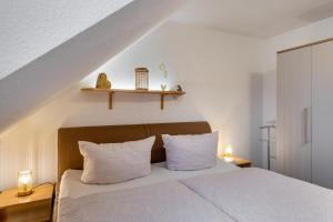 a bedroom with a white bed with two white pillows at Domizil Eden - Obergeschoss in Göhren-Lebbin