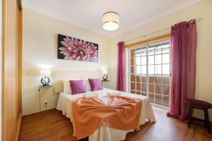 a bedroom with a bed with purple pillows and a window at My Friendly House in Lagos
