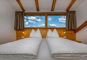 two beds in a room with a window at Vernalhof Apt Panorama in Sluderno