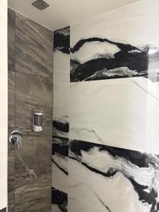ein Badezimmer mit einer Duschkabine aus schwarz-weißem Marmor in der Unterkunft Hotel Royal Puebla in Puebla + 42 Fotos