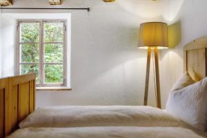 a bedroom with a bed with a lamp and a window at Ansitz Baumannhof Apt Mitte in Falzes