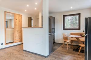 a kitchen with a table and a refrigerator at Villa Lara Zirbe in Castelrotto