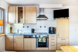 a kitchen with wooden cabinets and a sink and a stove at Apart Joachim in Fügen +15 photos