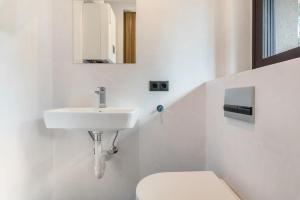 a white bathroom with a sink and a toilet at Villa Lara Zirbe in Castelrotto +17 photos