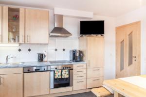 a kitchen with wooden cabinets and a stove top oven at Apart Joachim in Fügen