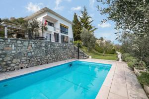 a swimming pool in front of a house at Villa Bianca in Toscolano Maderno