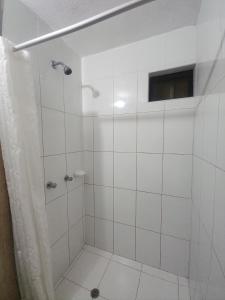 a bathroom with a shower with white tile at Hospedaje costa pacífico in Chimbote