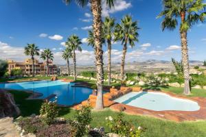 a pool with palm trees and a resort at Appartement avec 2 piscines in Mutxamel