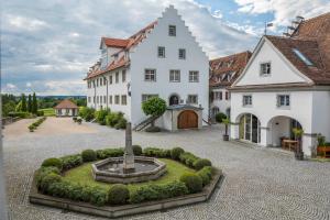 a large white building with a fountain in a courtyard at Schloss Kirchberg - Rose in Immenstaad am Bodensee