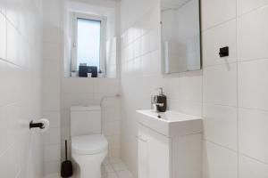 a white bathroom with a toilet and a sink at Zeitlos Zuhause Bregenz in Bregenz +17 photos