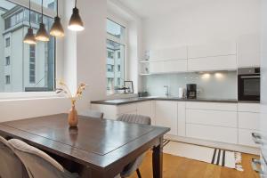 a kitchen with a wooden table with chairs and a dining room at Zeitlos Zuhause Bregenz in Bregenz