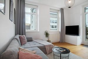 a living room with a couch and a tv at Zeitlos Zuhause Bregenz in Bregenz