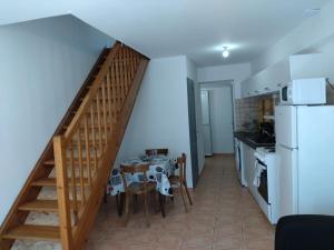 a kitchen with a staircase and a table and a refrigerator at La Clef in Saint-Julien-Molin-Molette