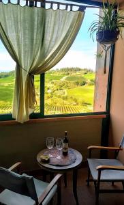 a table with two wine glasses in front of a window at Casa Bice in Marcialla