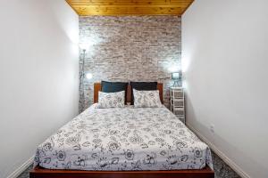 a bedroom with a bed and a brick wall at Casinha do Monte in Achadinha