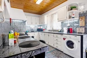 a kitchen with a washer and dryer on a counter at Casinha do Monte in Achadinha +19 photos