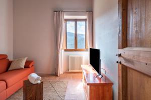 a living room with a couch and a television at Gea - In Parulia Country House in Arezzo