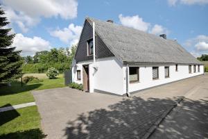 a white building with a gray roof at An der Rehkoppel in Boren