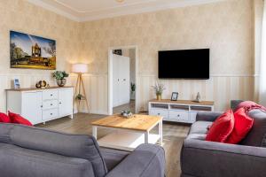 a living room with two couches and a flat screen tv at Ferienhaus Optikstadt Rathenow in Rathenow