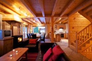 a living room with a couch and a television in a cabin at Chalet Myrtille in Morzine