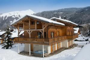 a log cabin in the snow with snow at Chalet Myrtille in Morzine