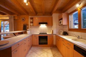 a kitchen with wooden cabinets and a stove top oven at Chalet Myrtille in Morzine