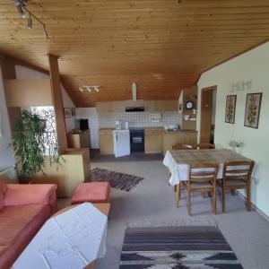 a living room with a table and a kitchen at Haus Maria Bodensdorf in Tratten +15 photos