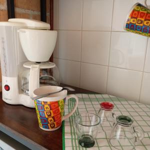 a counter with a coffee maker and cups on it at La Casa del Zuf in Carlino +46 photos