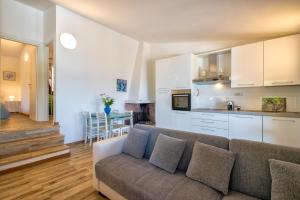 a living room with a couch and a kitchen at Villa Aloe in Costa Paradiso
