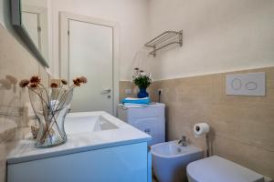 a bathroom with a white sink and a toilet at Villa Aloe in Costa Paradiso