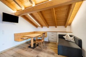 a dining room with a table and a couch at Matscherhof Ferienwohnung Helena in Santa Valpurga