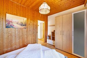 a bedroom with wooden walls and a bed and a cabinet at Wohnung Elstar Schnalserhof in Laces