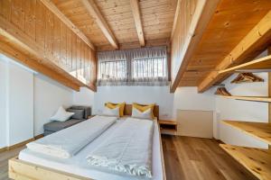 a large bed in a room with wooden ceilings at Matscherhof Ferienwohnung Helena in Santa Valpurga