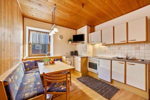 a kitchen with white cabinets and a table with a chair at Wohnung Elstar Schnalserhof in Laces