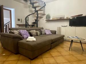 a living room with a brown couch and a staircase at Alle Rive apartment in Salò