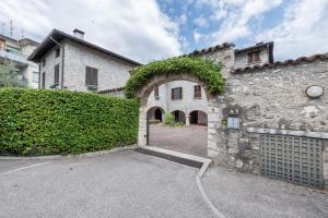 an entrance to a stone building with an archway at Alle Rive apartment in Salò