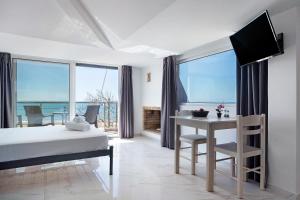a bedroom with a bed and a desk with a view of the ocean at Iguana studio 18 in Preveza