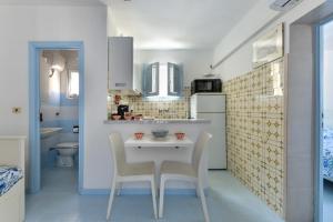 a kitchen with a table and chairs in a room at Villa Oda - Bilocale sul mare in Capoliveri +11 photos