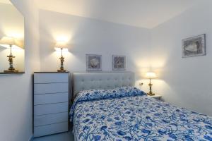 a bedroom with a blue and white bed and two lamps at Villa Oda - Bilocale sul mare in Capoliveri