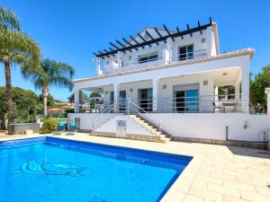 a villa with a swimming pool in front of a house at Fustera in Benissa