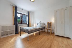 a bedroom with a bed and a window and a chair at Gemütliche Wohnung Buchholz i d N in Buchholz in der Nordheide