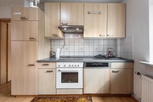 a kitchen with wooden cabinets and a stove top oven at Gemütliche Wohnung Buchholz i d N in Buchholz in der Nordheide