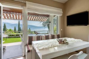 a dining room with a table and a large window at Ferienwohnung Casa 50 in Gargnano