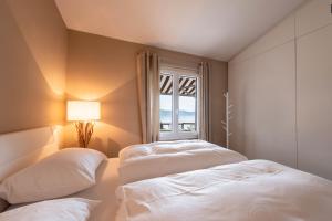 two beds in a room with a window at Ferienwohnung Casa 50 in Gargnano +17 photos