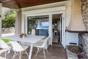 a white dining table and chairs on a patio at Ferienwohnung Casa 50 in Gargnano