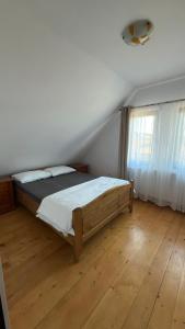 a bedroom with a bed and a wooden floor at Figa Retreat in Beclean