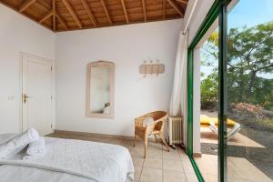 a bedroom with a bed and a chair and a mirror at La Villa La Palma- 1 dormitorio A in Los Barros +21 photos